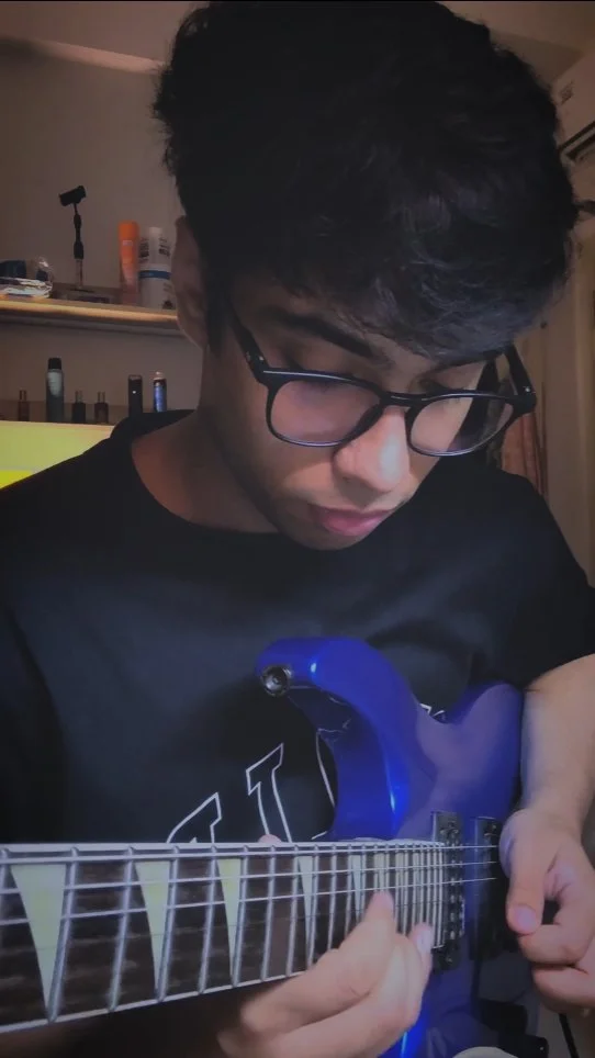 Trishit playing electric guitar in a reel with Saarang