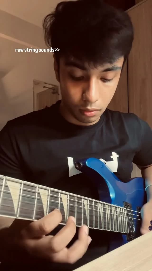 Trishit playing his blue electric guitar